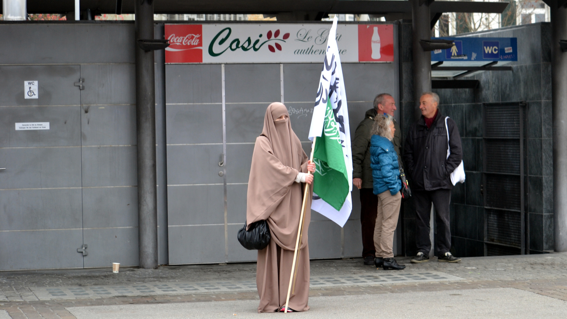 Niqab-Trägerin mit islamischen Fahnen