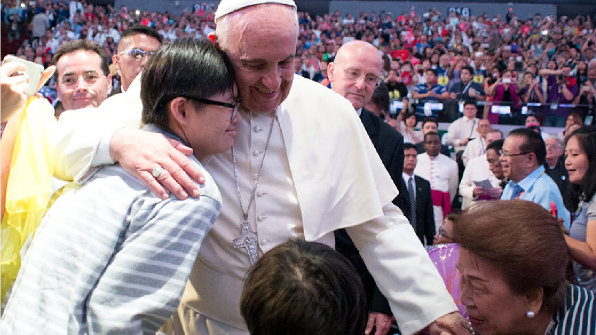 Papst Franziskus umarmt einen Jugendlichen