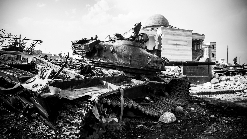 Ein zerstörter Panzer der syrischen Armee, im Hintergrund die zerstörte Moschee der syrischen Grenzsstadt Azaz