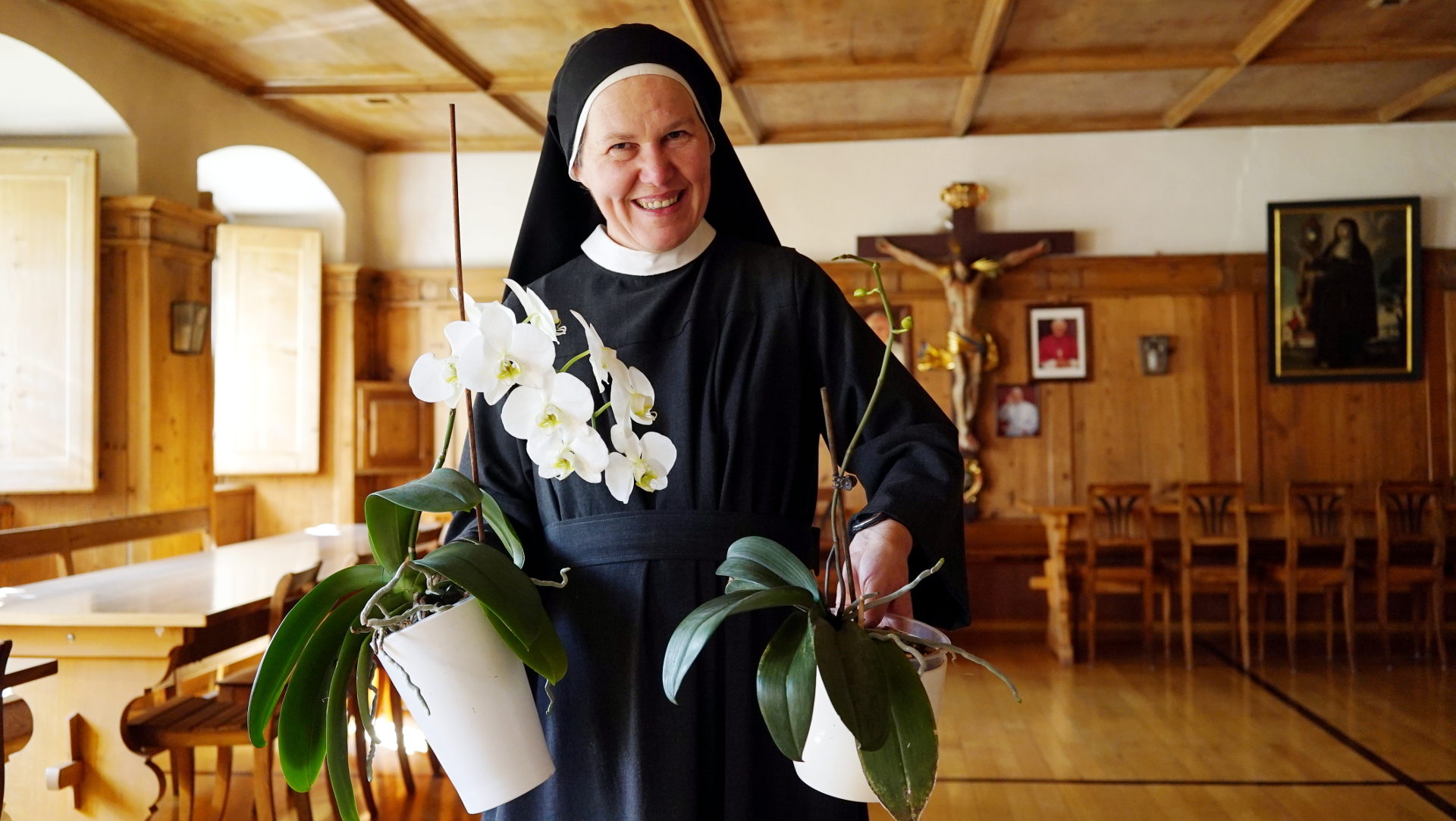 Sr. Agatha Kocher mit Orchideen im Refektorium