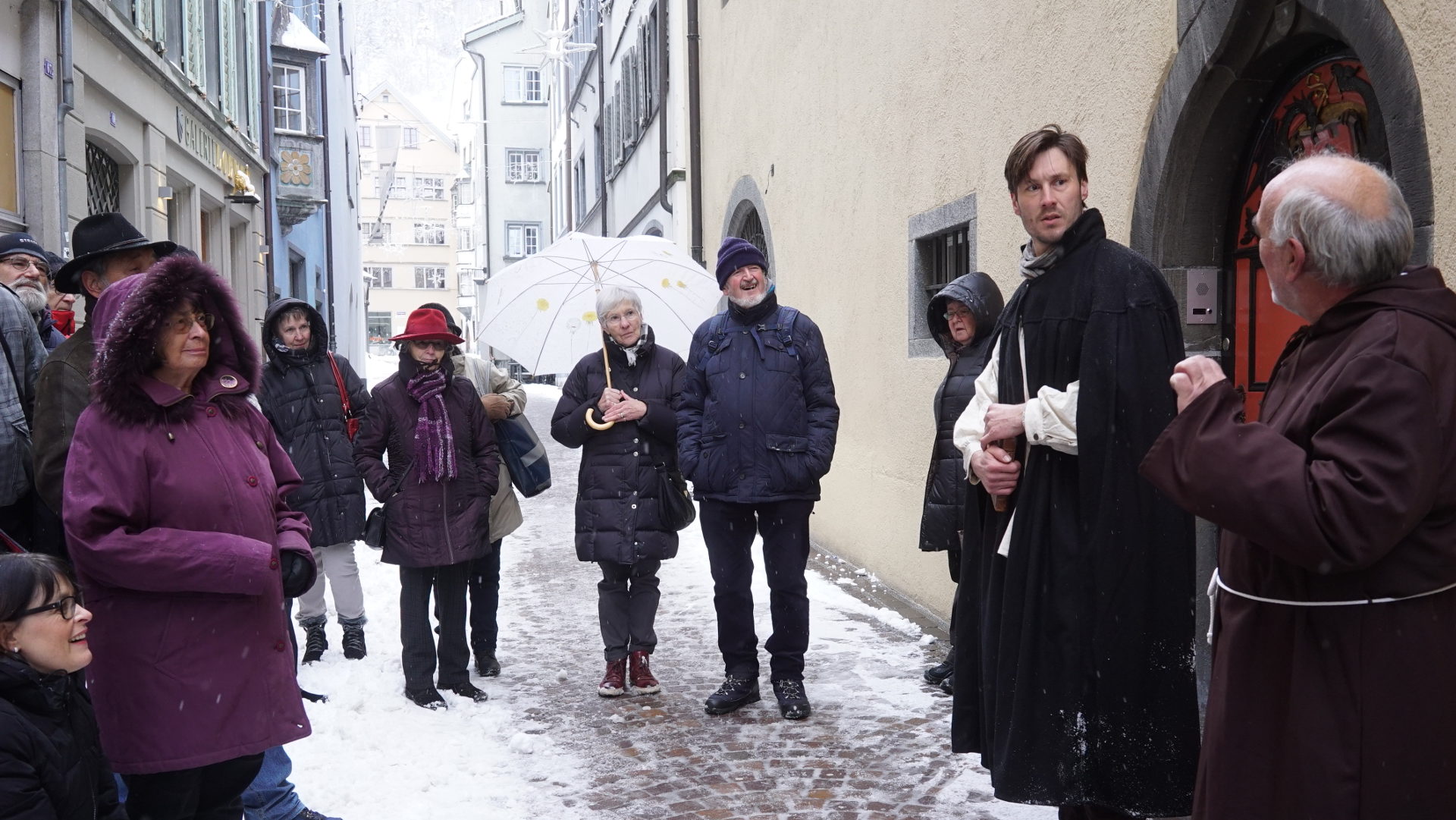 Zwei Schauspieler spielen auf einem Stadtrundgang in Chur eine Szene nach aus dem Leben des Bündner Reformators Johannes Commander.