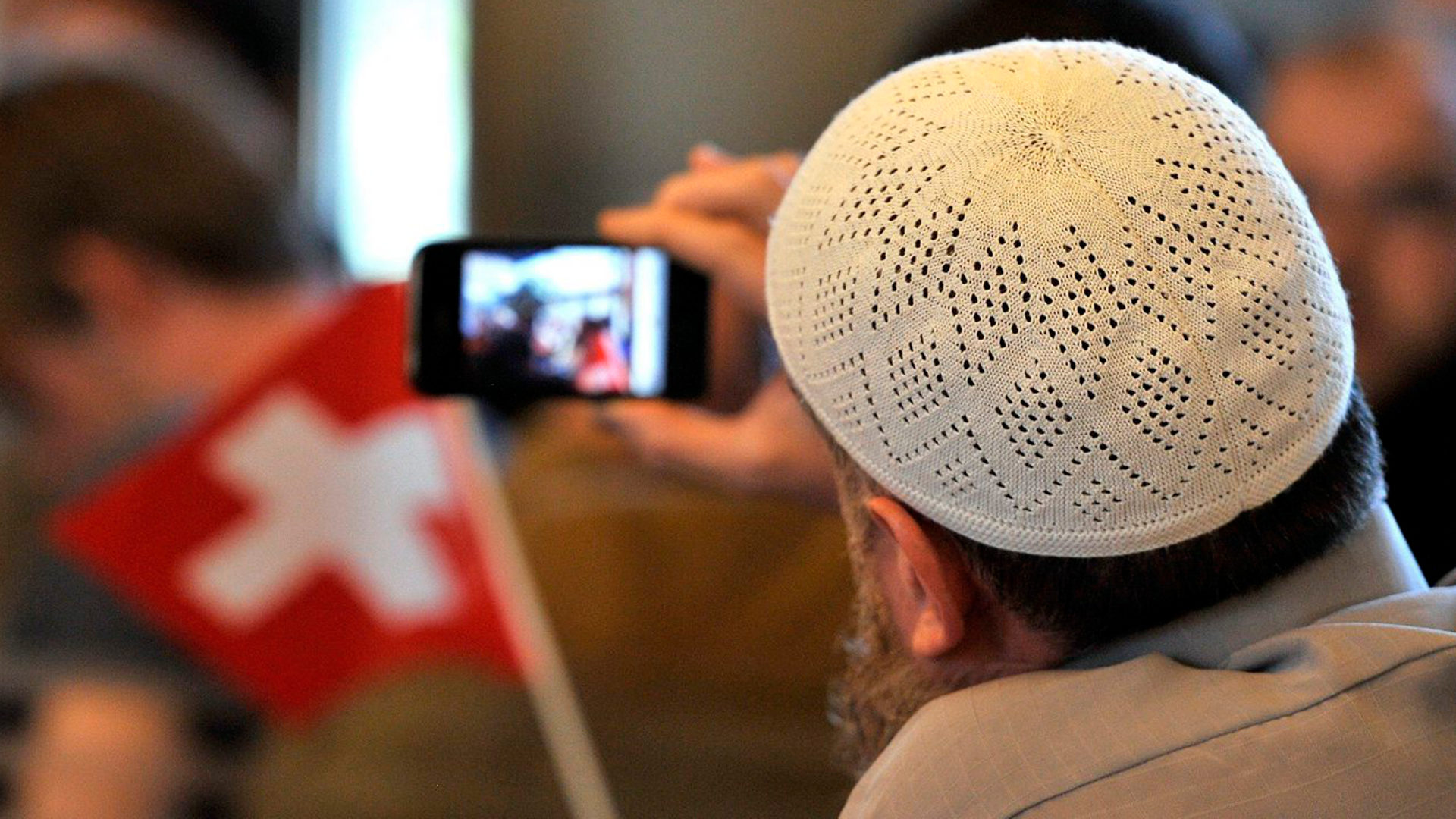 Ein Muslim macht Fotos mit seinem Mobiltelefon.
