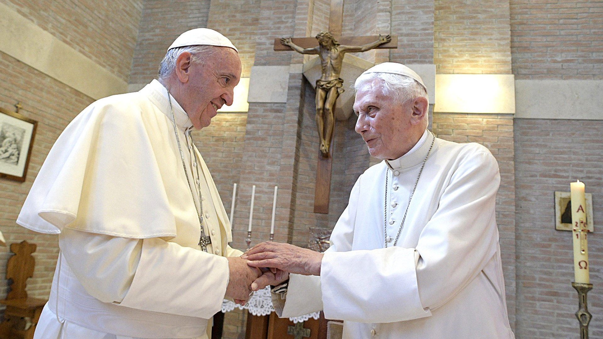 Papst Franziskus und der emeritierte Papst Benedikt XVI. (rechts) reichen sich die Hände am 28. Juni 2017 im ehemaligen Kloster "Mater Ecclesiae" im Vatikan.