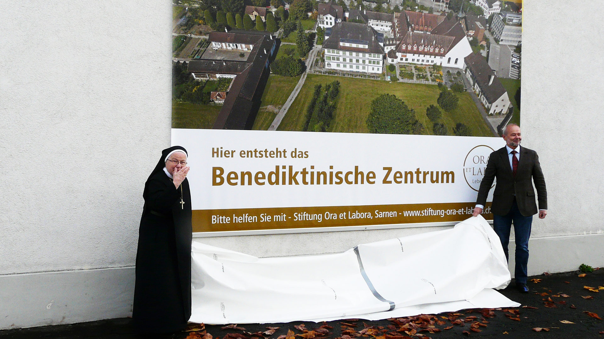 Enthüllung des Plakats «Benediktinisches Zentrum» an der Klostermauer in Sarnen: Äbtissin Mutter Pia Habermacher und Hanspeter Kiser