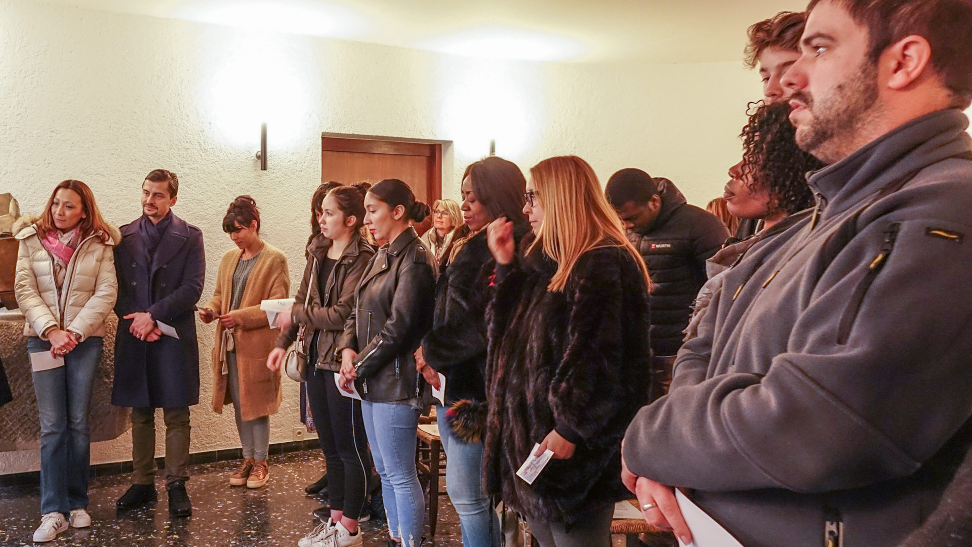 Frauen und Männer, die sich taufen lassen wollen, bei einem Treffen.