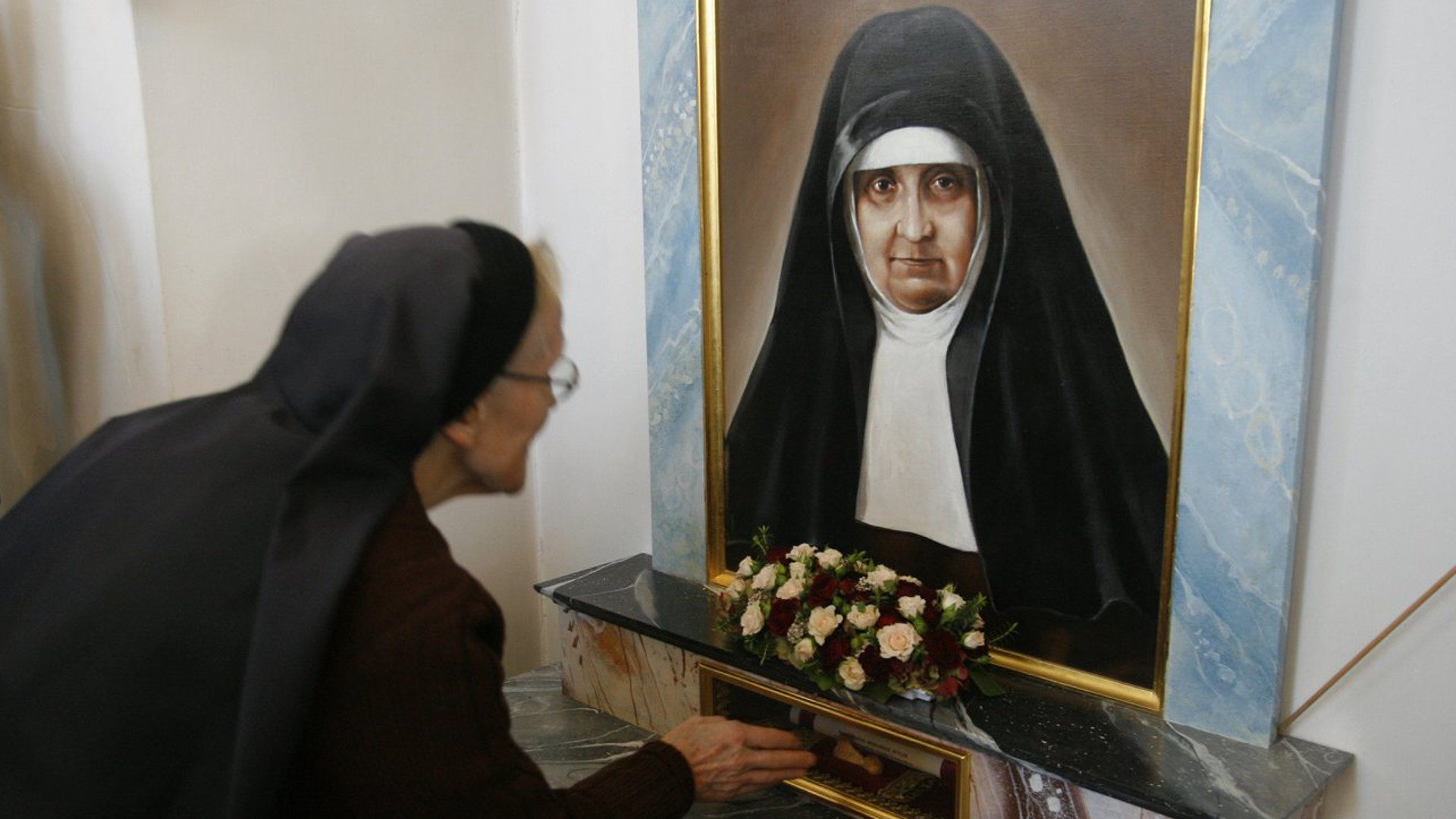 Eine Pilgerin berührt das Reliquium der Heiligen Maria Bernarda in der Pfarrkirche von Auw.