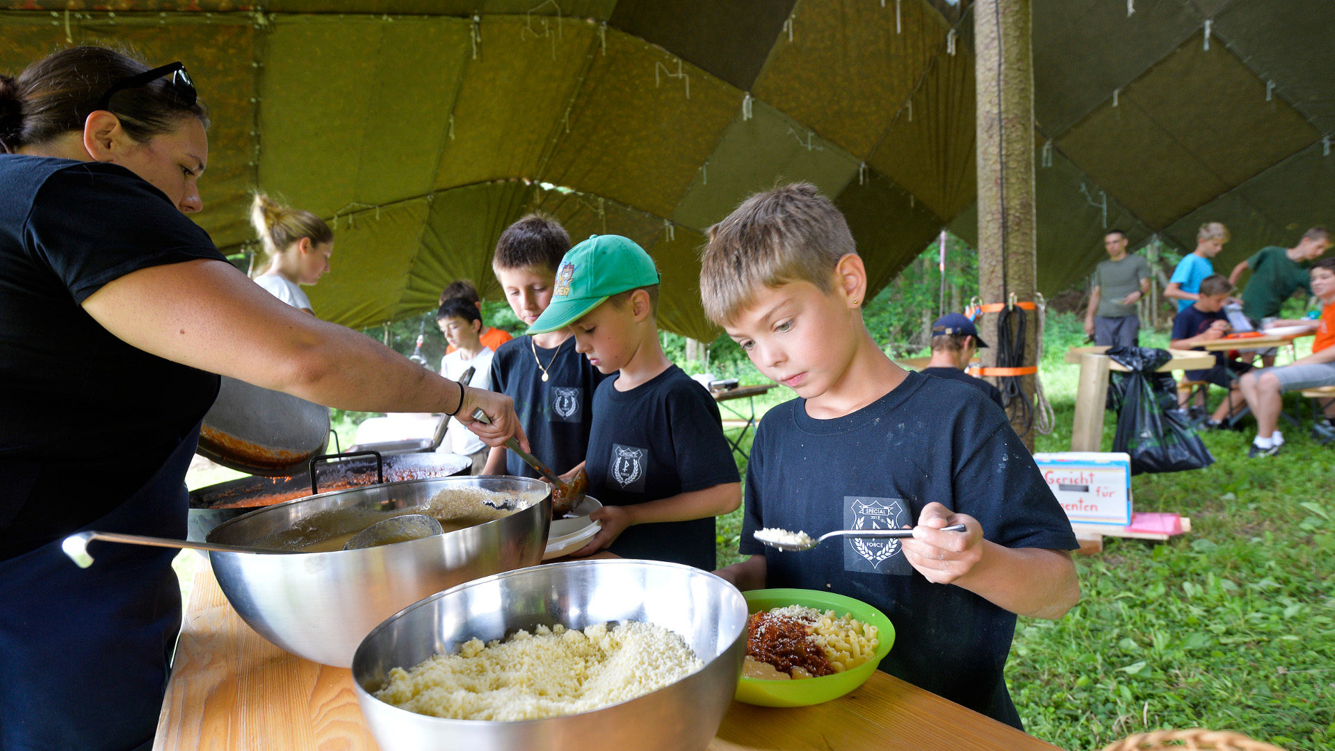 Jubla-Kinder schöpfen Essen unter dem  "Sarasani"-Zelt