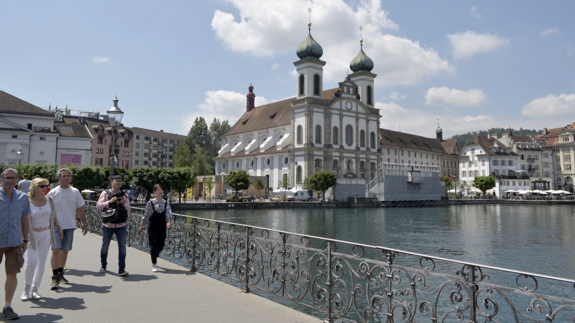 Touristen vor der Jesuitenkirche: Links im Hintergrund ist das weisse Gebäude des Luzerner Theaters zu sehen. Dazwischen liegt der Theaterplatz.