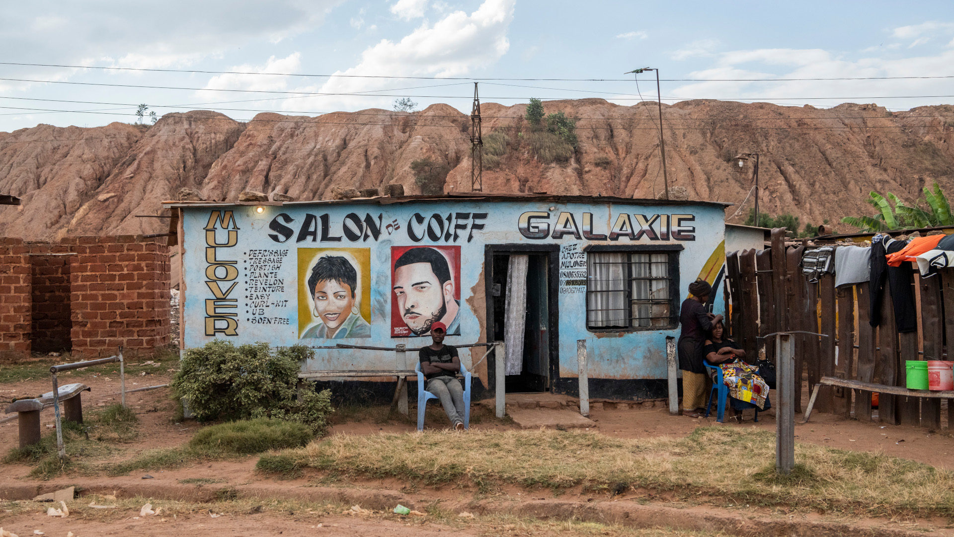 Coiffeursalon vor der Abräumhalde der Glencore-Kupfermine KCC in Kolwezi (Kongo)
