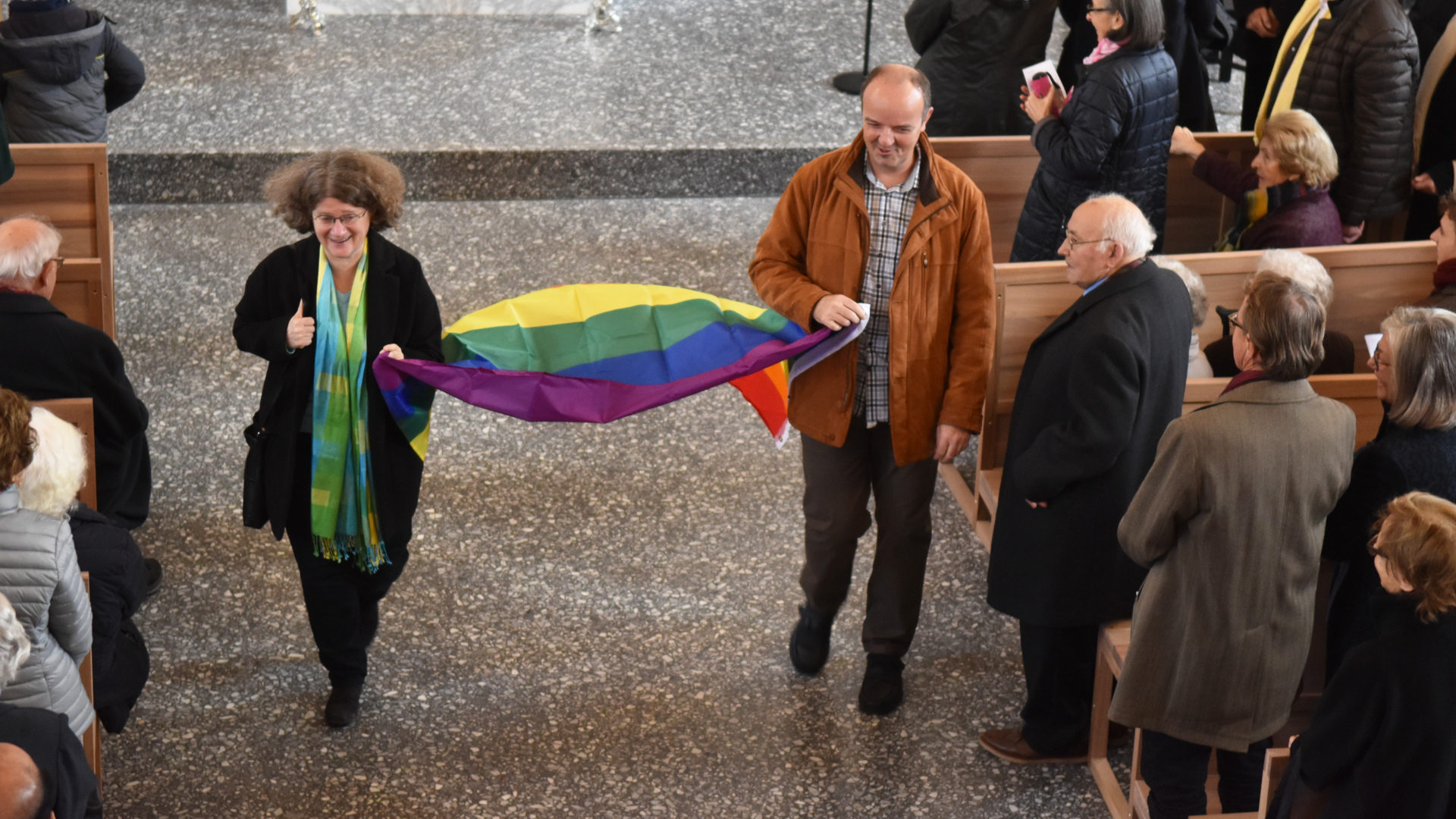 Auszug der LGBT-Fahne mit Nicola Neider, kirchliche Integrationsverantwortliche und Bruno Fluder, Regenbogenpastoral Bistum Basel