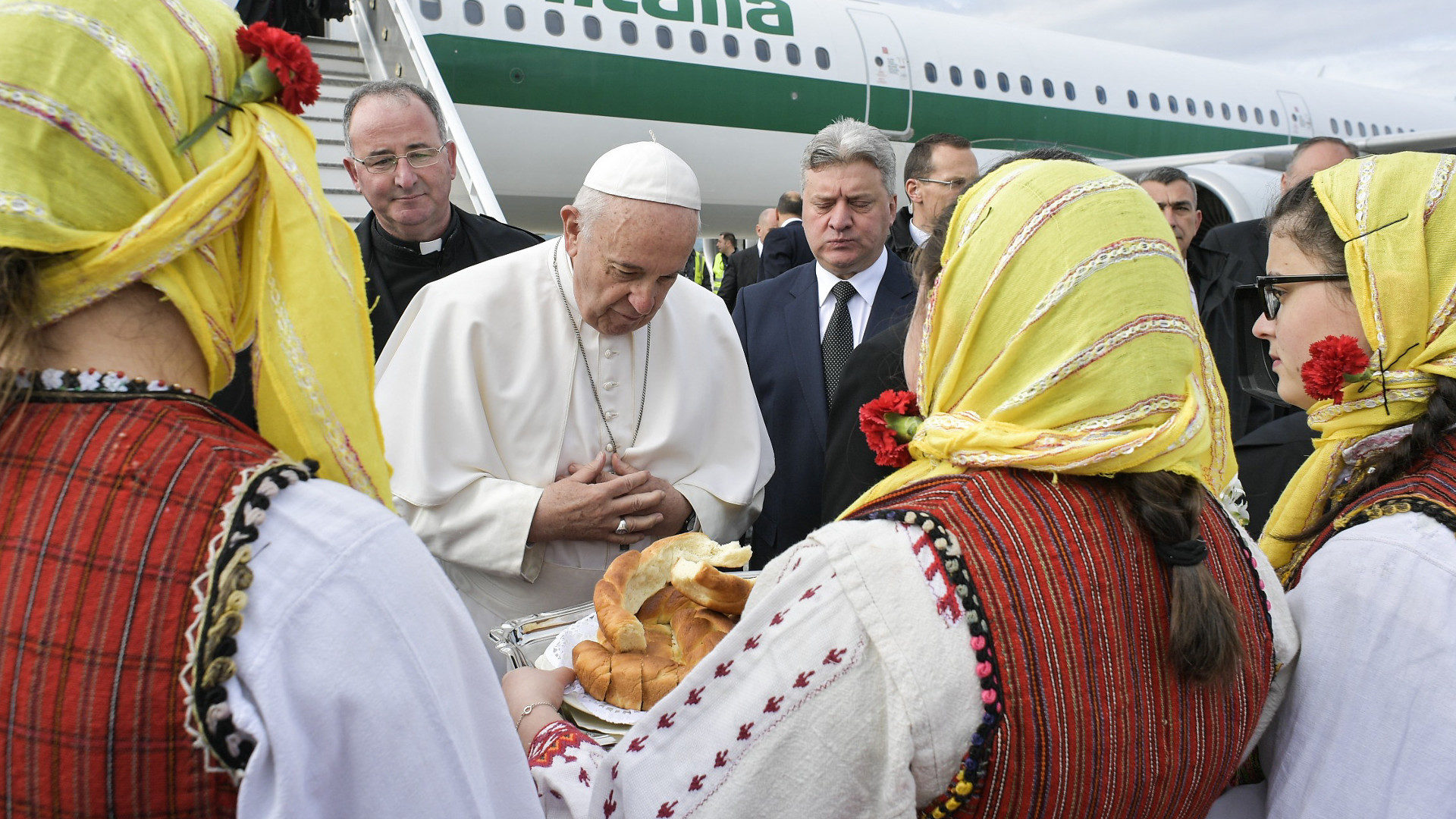 Papst Franziskus wird in Skopje von einer Gruppe Frauen in landestypischer Tracht beschenkt.