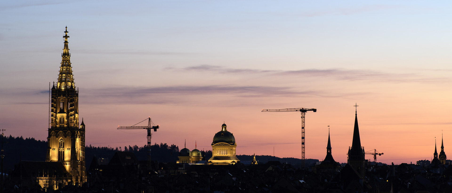 Auch Kirchen machen Politik. Münster und Bundeshaus in Bern bei aufgehender Sonne.