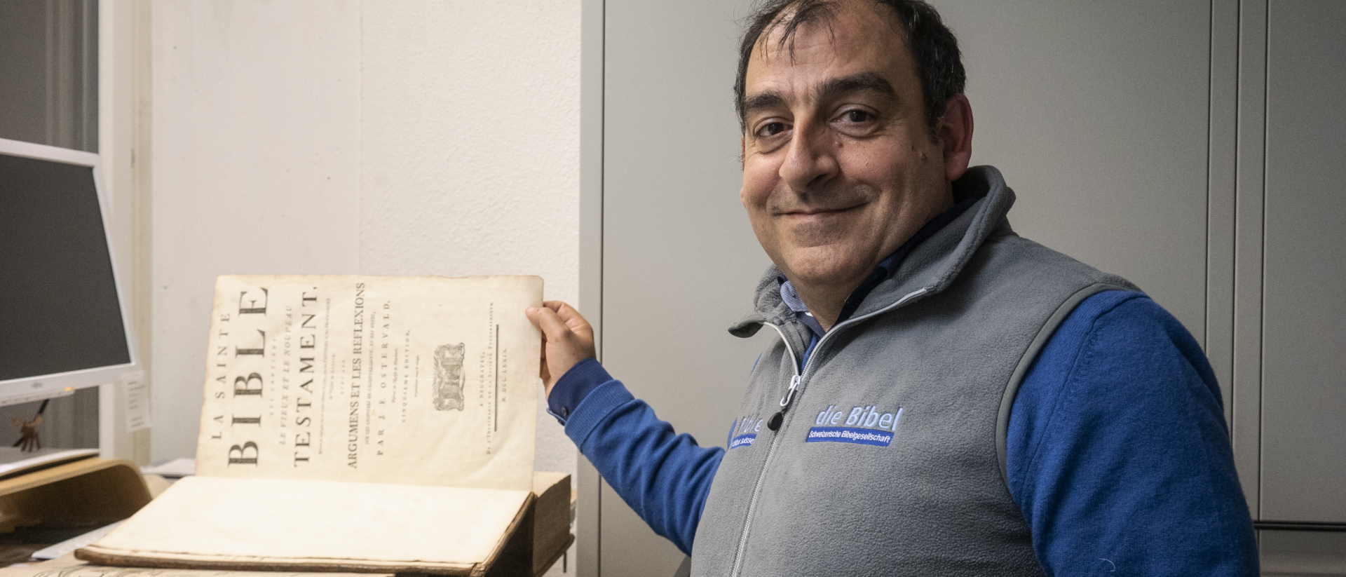 Lorenzo Scornaienchi mit einer alten Bibel in der "Schatzkammer" der Bibelgesellschaft