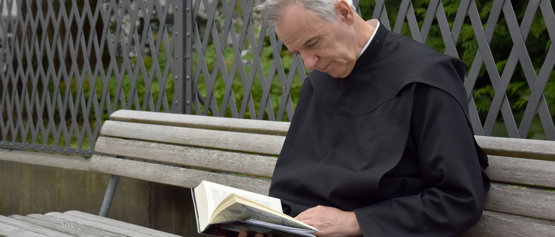 Bruder Gerold Zenoni beim Lesen im Abteihof des Klosters Einsiedeln.