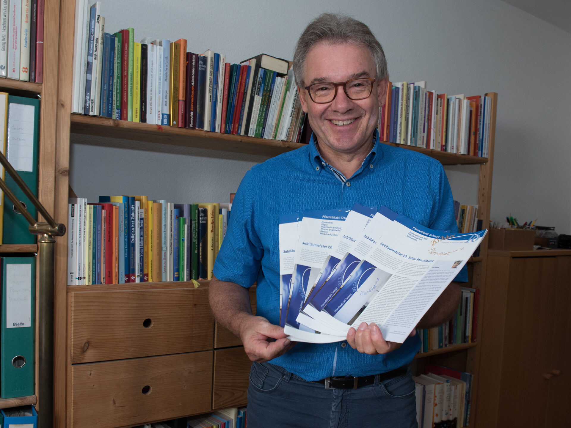 Mantelredaktor Eugen Koller mit den regionalen Ausgaben des Pfarreiblatts.