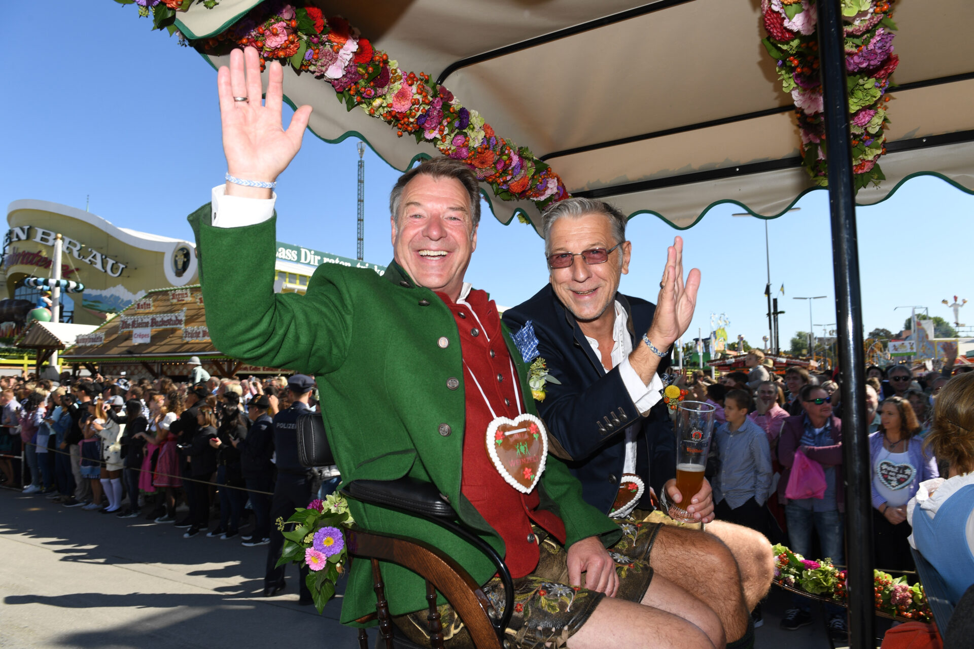 Das ist keine Hochzeitskutsche, sondern ein Archiv-Bild. Der Sänger Patrick Lindner (links) und sein Partner Peter Schäfer winken auf dem Oktoberfest beim Einzug der Festwirte. Das Foto stammt von 2019.