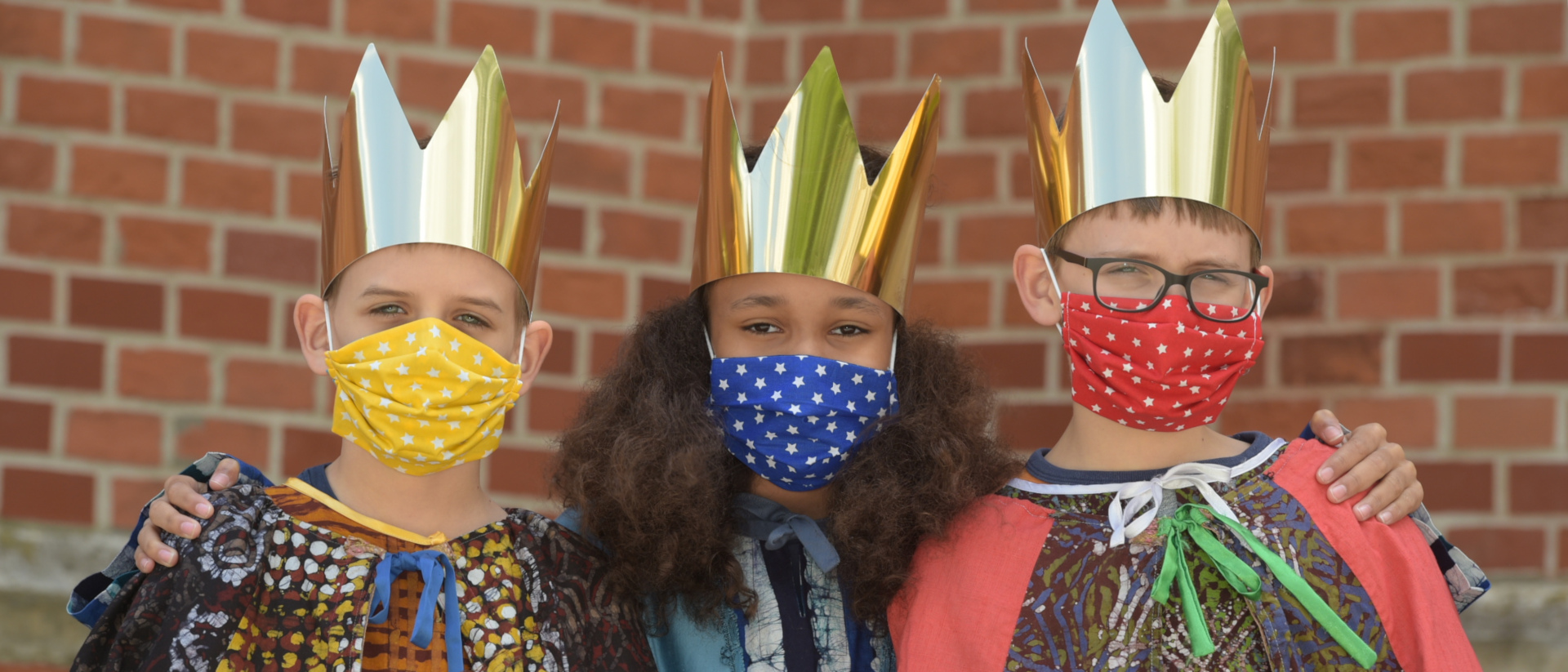 2021: Sternsingerin und Sternsinger mit Maske