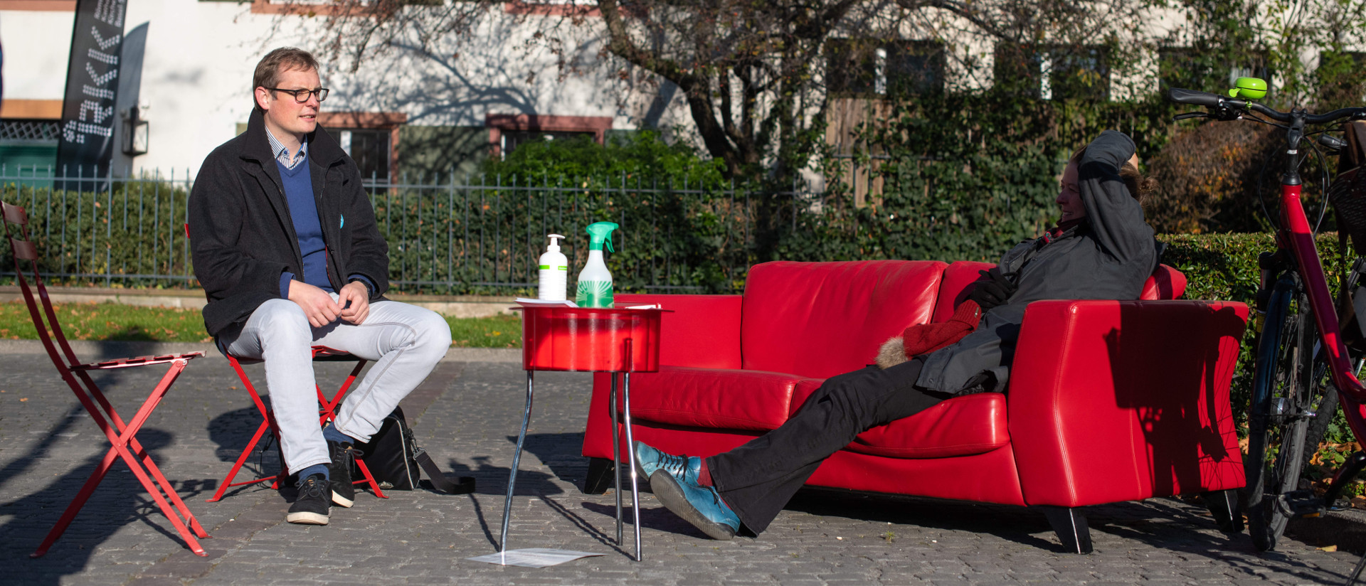 Der Priester Martin Föhn im Gespräch mit einer Passantin auf dem roten Sofa der gleichnamigen Aktion in Basel.