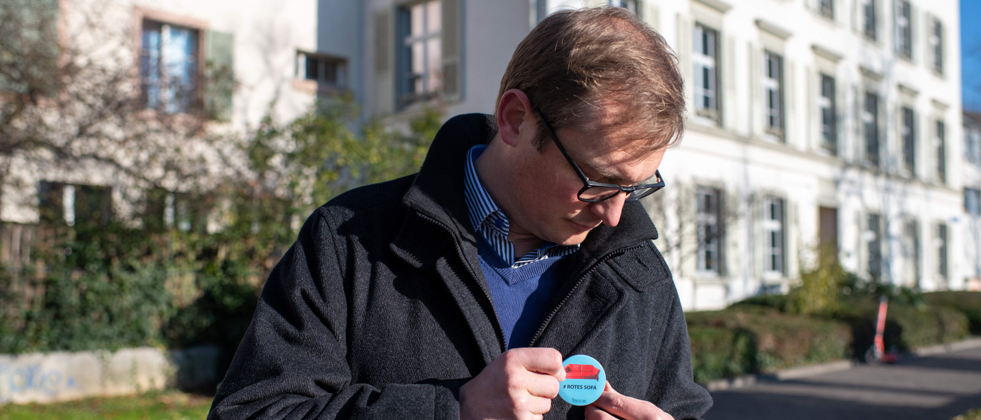 Martin Föhn steckt sich den Pin an für die Aktion #RotesSofa.