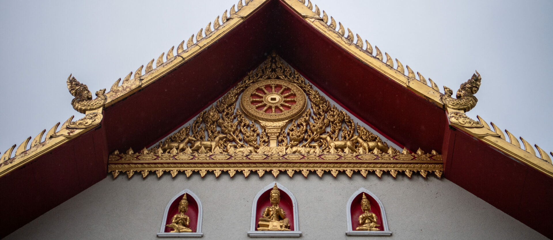 Typisch für thaibuddhistische Tempel ist das Gebäude aussen golden verziert.