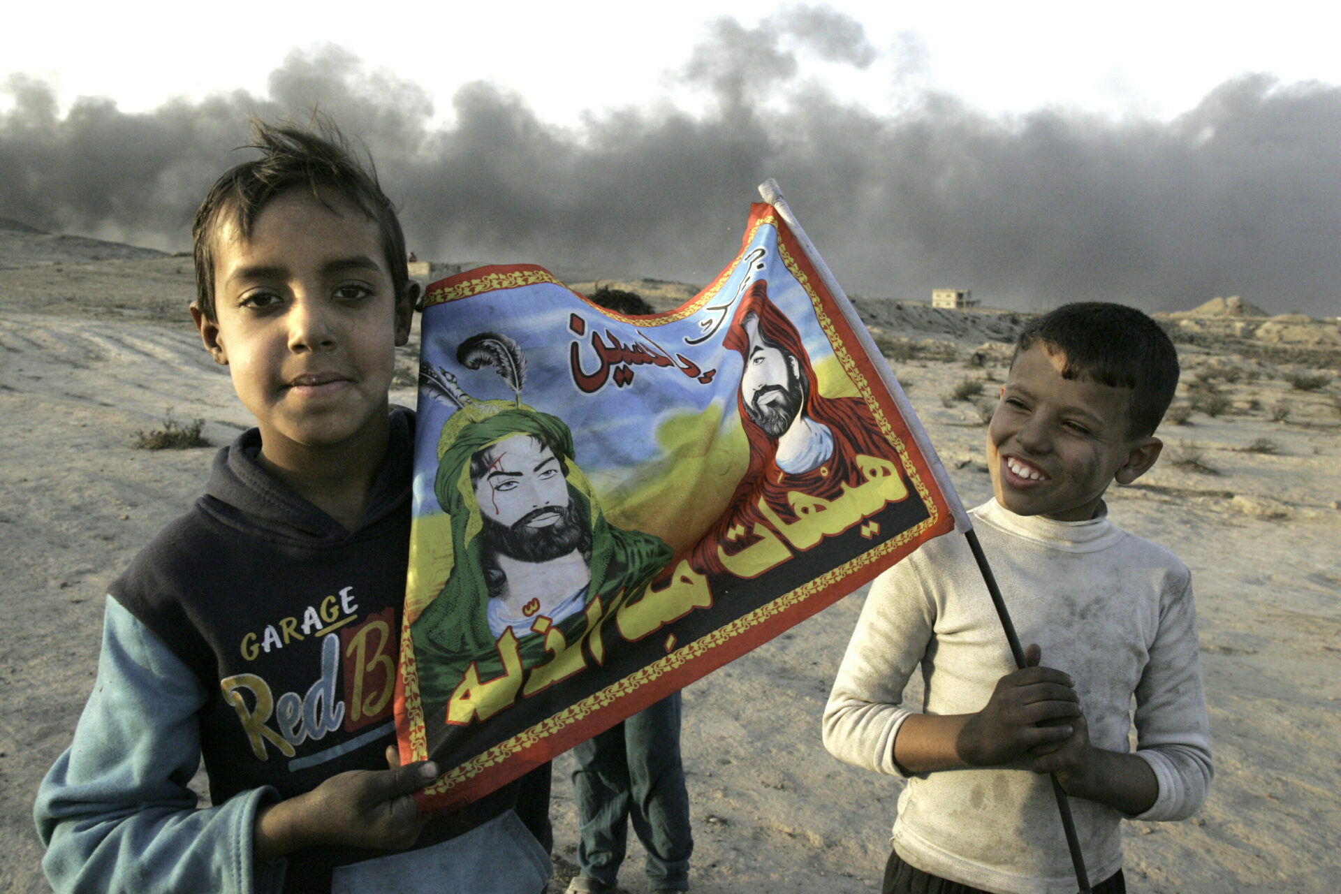 Zwei Kinder im Irak. Auf der Fahne sind die Imame Hussein und Ali zu sehen – Verwandte des Propheten Mohammed. Sie werden von den Schiiten als Kriegshelden und Märtyrer verehrt.