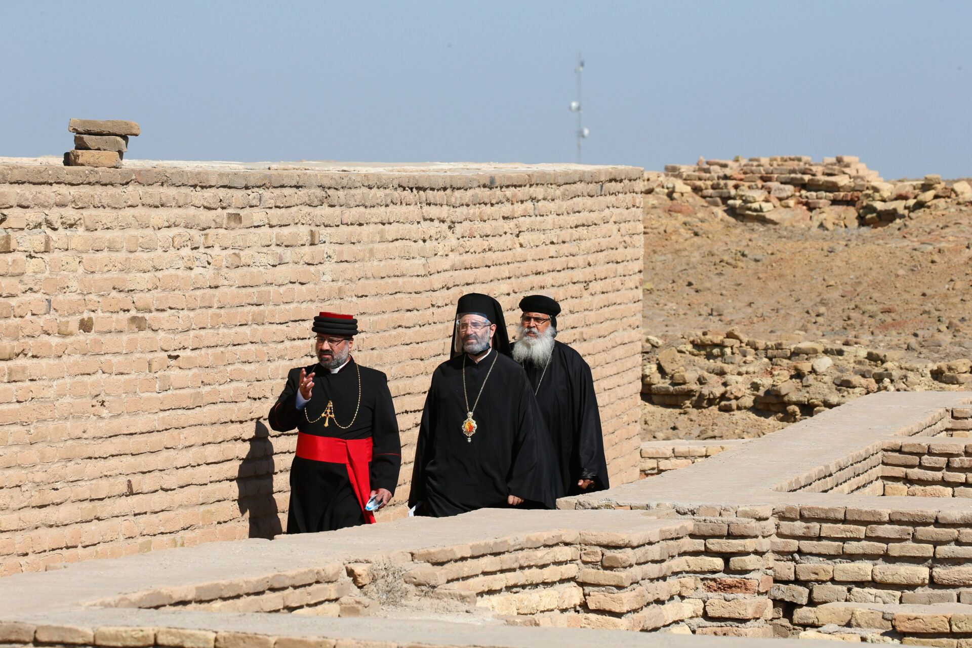 Prälaten gehen durch die Ruinen der antiken Stadt Ur vor dem interreligiösen Treffen mit Papst Franziskus.