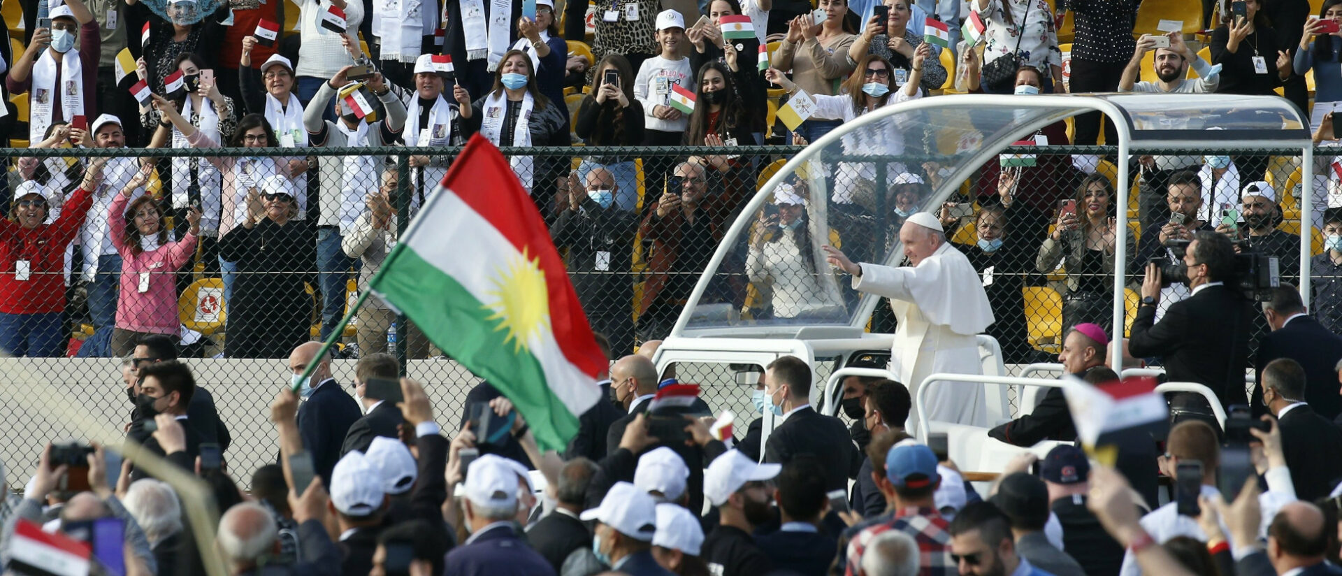 Menschen jubeln in Erbil Papst Franziskus zu.