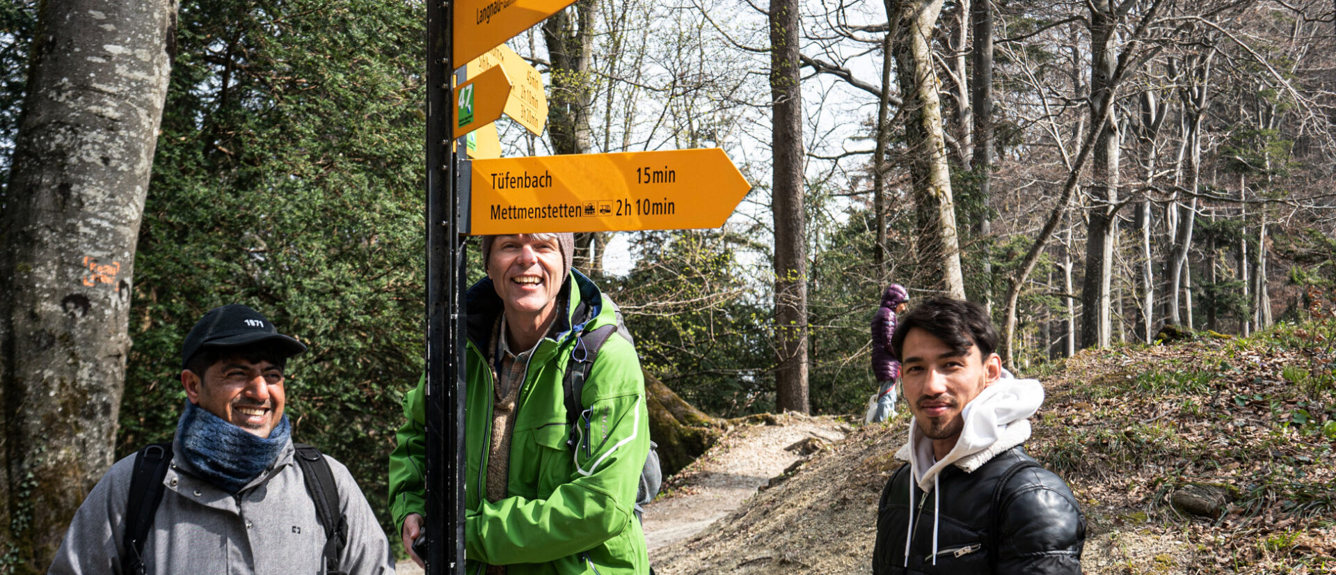 Karim, Christoph Albrecht und Hasan an einem Wegweiser.
