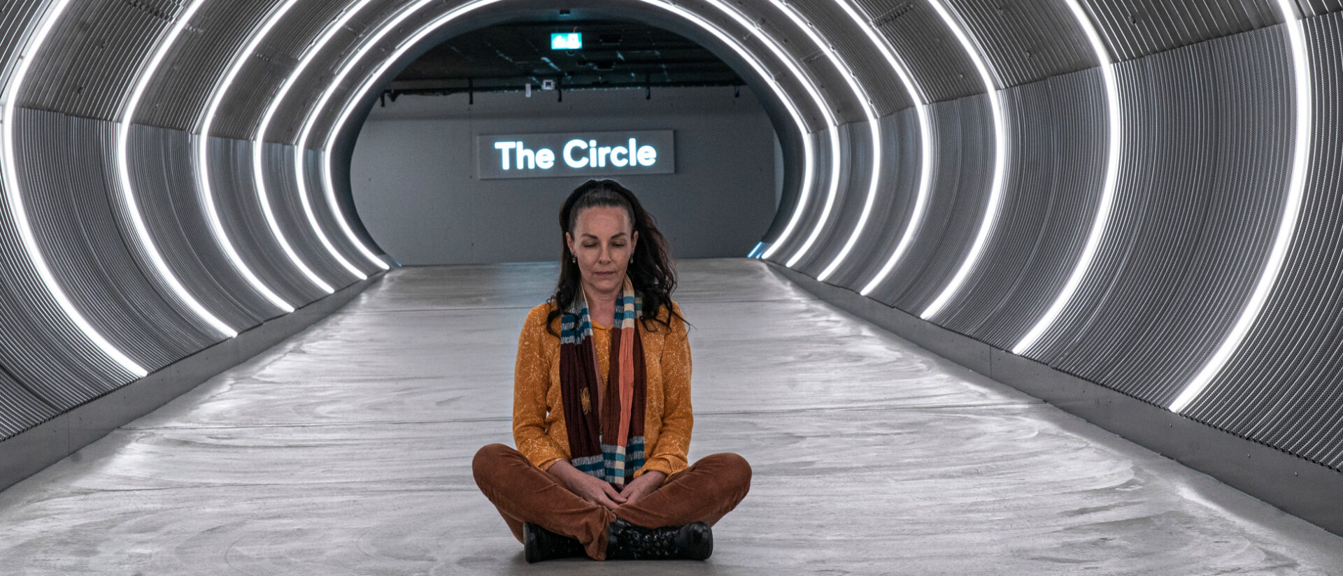 Andrea Thali meditiert auf dem Boden im Durchgang zum neuen Stadtviertel The circle