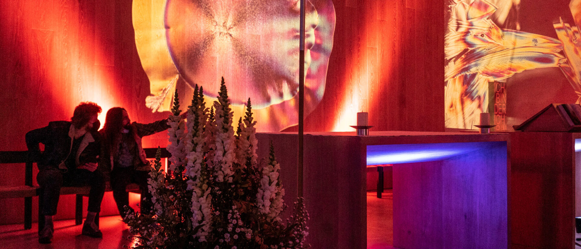 Besuchende sehen sich die Lichtinstallation in der Kirche Heilig Geist an.