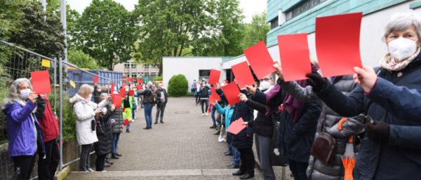 Demonstrantinnen zeigen Kardinal Rainer Maria Woelki die Rote Karte. | © KNA