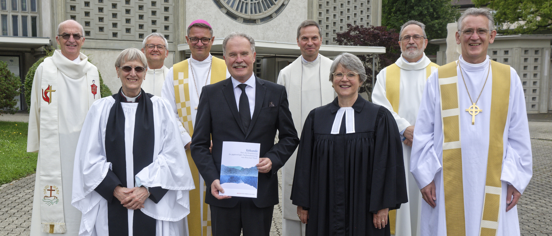 Der Vertreter der Neuapostolischen Kirche, Jürg Zbinden (Mitte), erhält die Taufanerkennung von den anderen Kirchen der AGCK.CH.