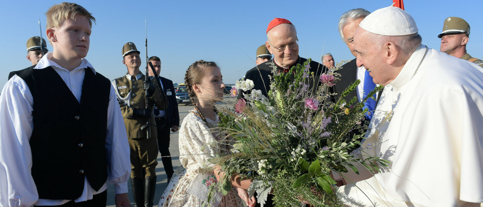 Ein Mädchen überreicht Papst Franziskus einen Blumenstrauss bei dessen Ankunft in Budapest.