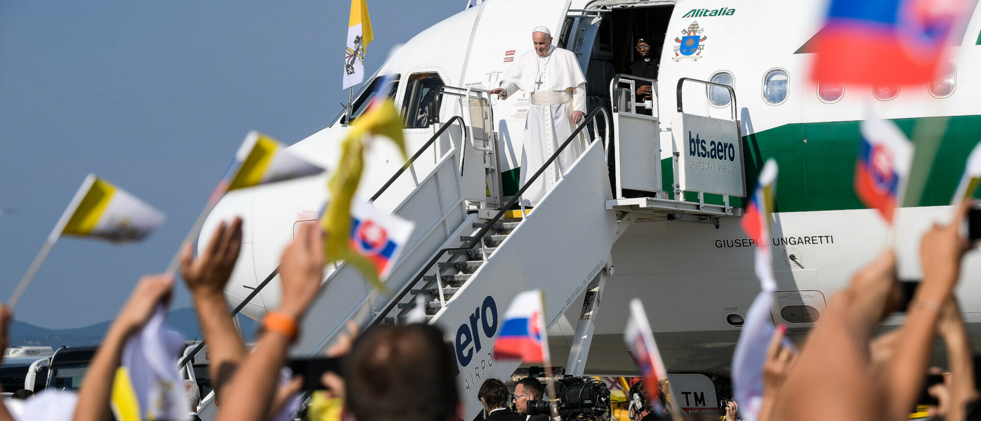 Menschen schwenken mit Fähnchen bei der Ankunft von Papst Franziskus in Bratislava (Slowakei) am 12. September 2021.