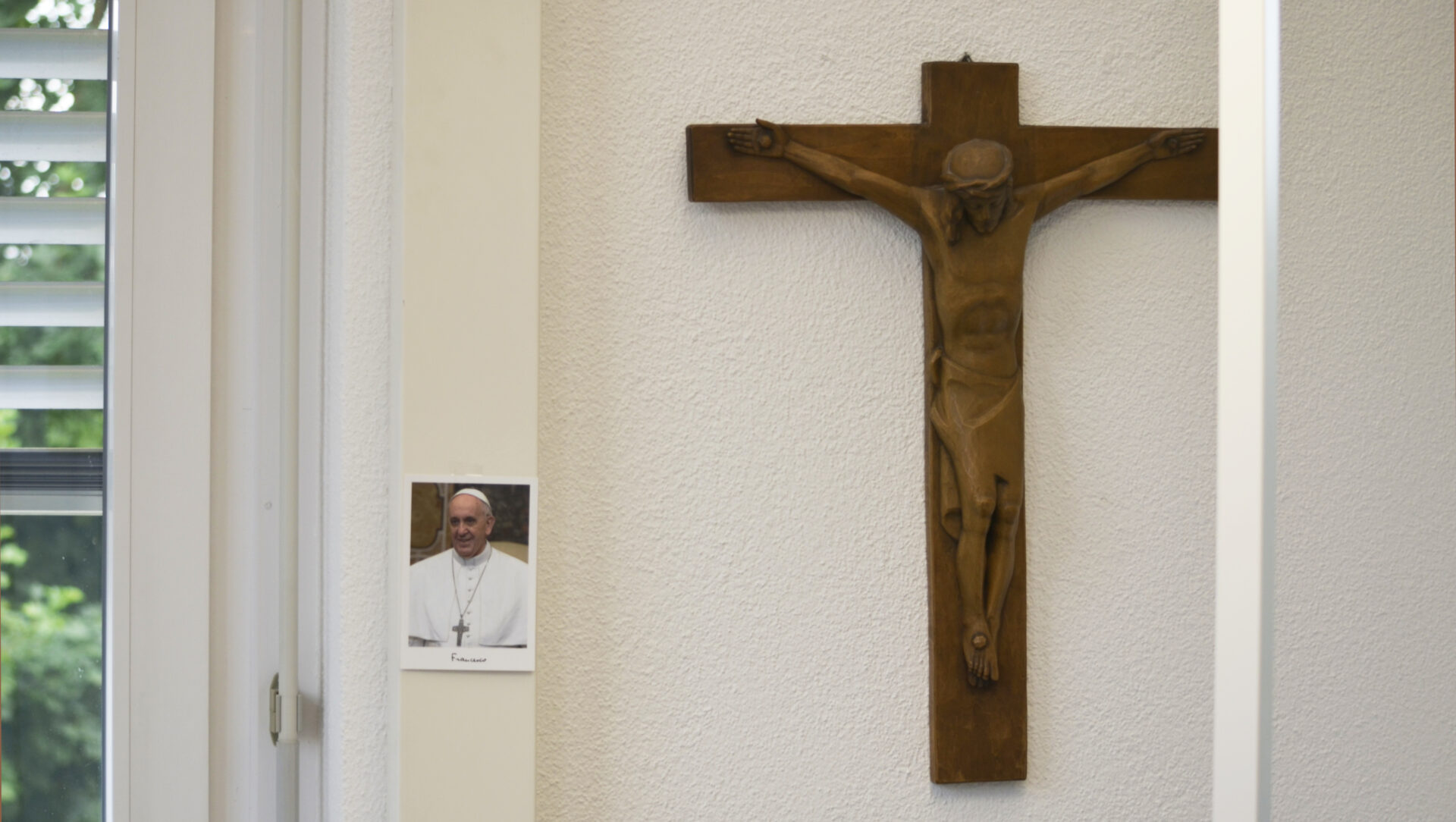 Eine Foto von Papst Franziskus und ein Kruzifix zieren die Bürowand von Urban Fink.