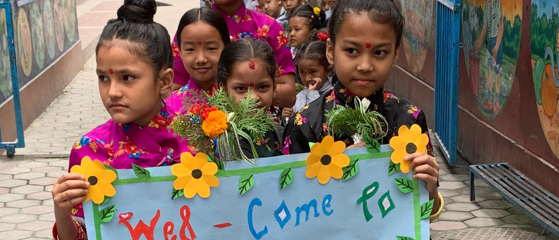 Kinder in Nepal begrüssen die Schweizer Reisegruppe aus Thun, geleitet von Sonja Lofaro.