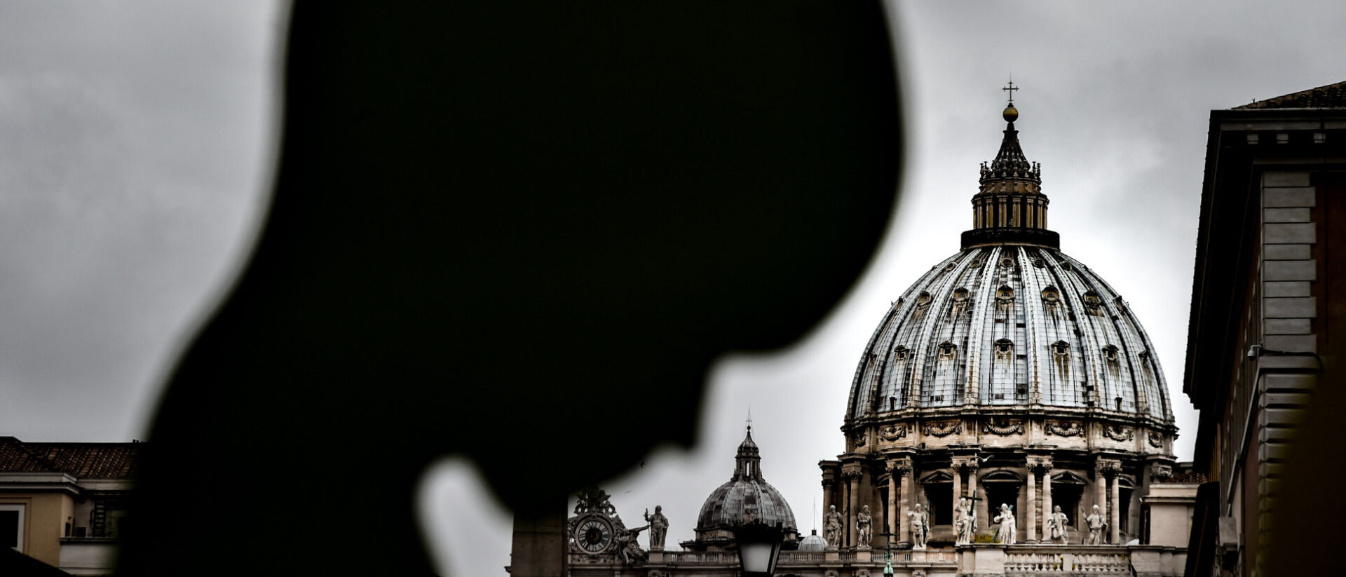 Im Vordergrund ist die Figur von einem Embryo, im Hintergrund die Kuppel des Petersdoms zu sehen.