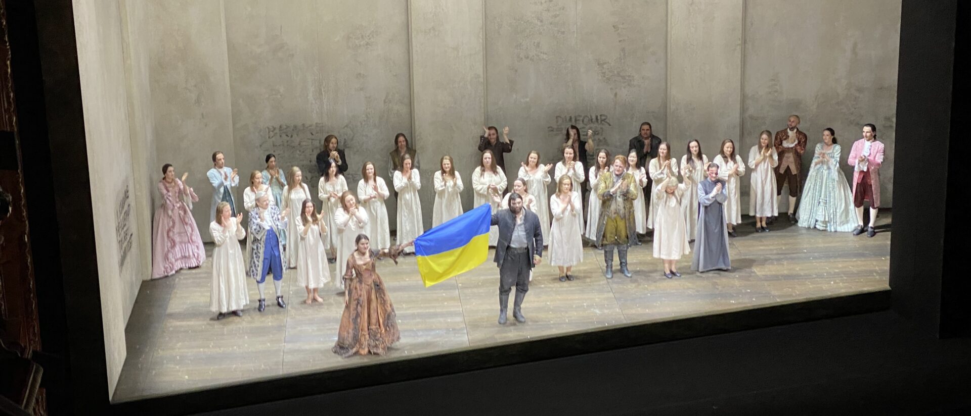 Olga Kulchynska und Valeriy Murga erscheinen zum Schlussapplaus am Opernhaus Zürich mit der ukrainischen Flagge.