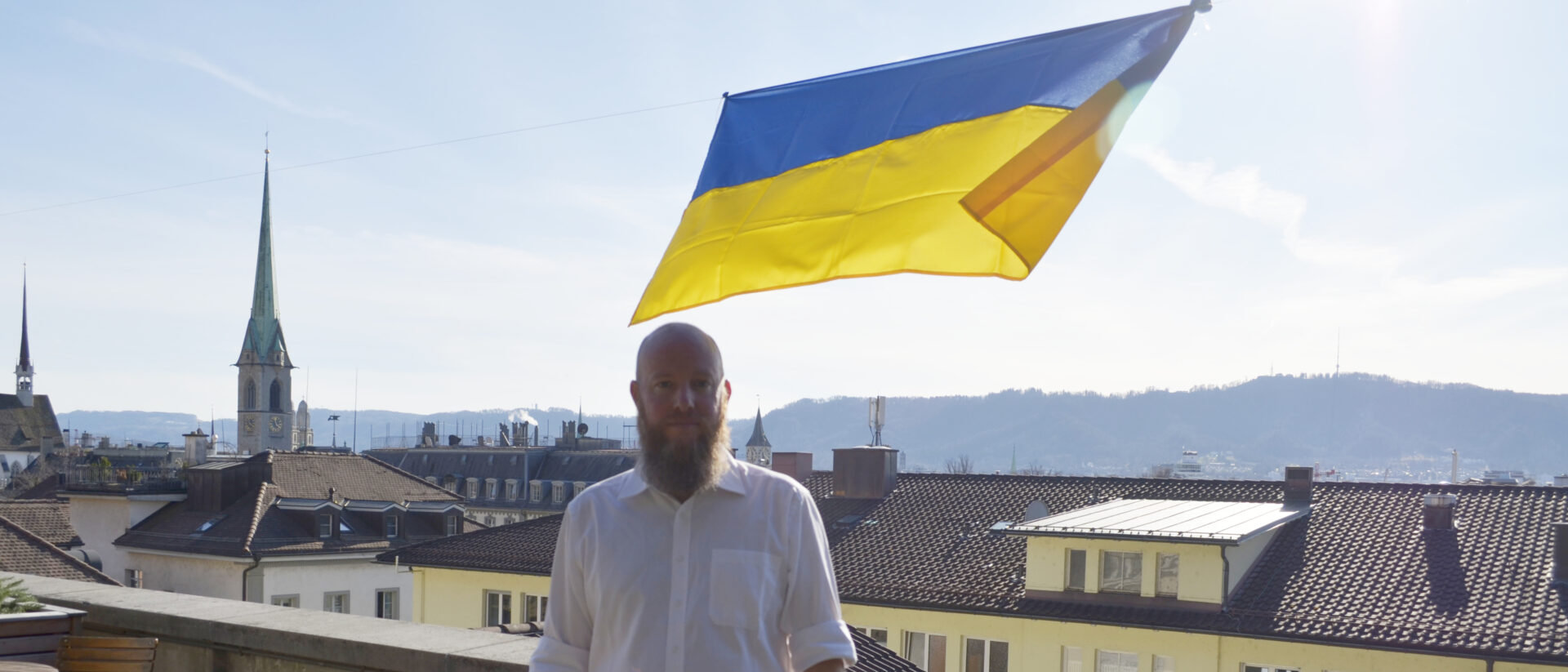 Mathias Werfeli vor der Ukraine-Fahne, die er mit Studierenden gehisst hat.
