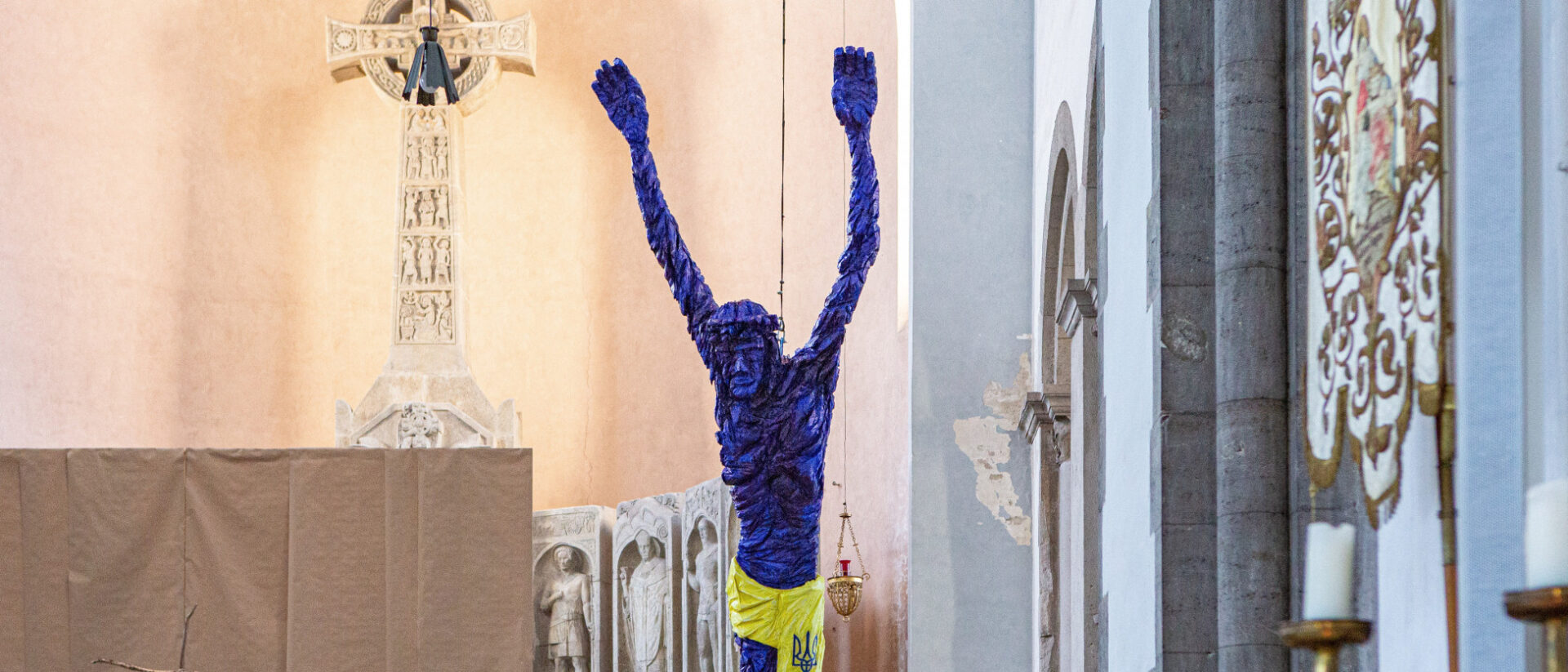 Eine überdimensionale Christusfigur in Blau mit gelbem Tuch des Künstlers Harry Seeholzer in München.