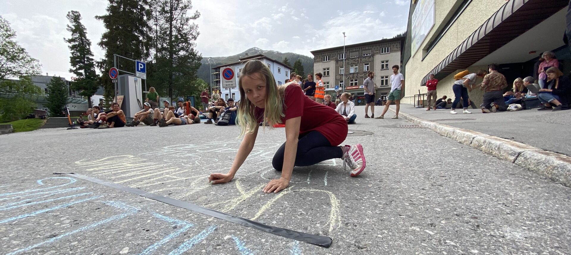 "Aufhören mit dem Töten in der Ukraine! Jetzt das vollständige Embargo verhängen!", schreibt Anastasiia Onufriv auf die Strasse in Davos.