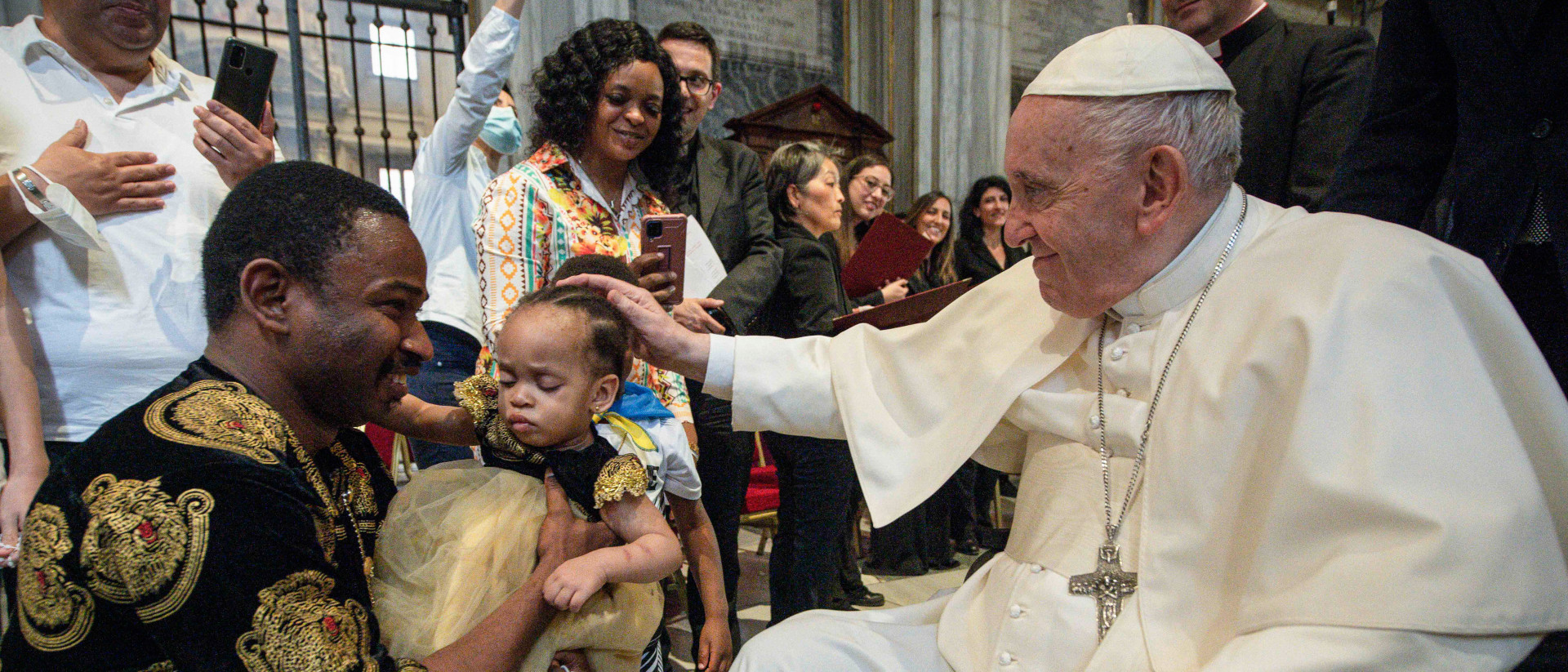 Pope Francis places his hand on the head of a little girl during the worldwide rosary prayer at the Church of Santa Maria Maggiore May 31, 2022 in Rome.