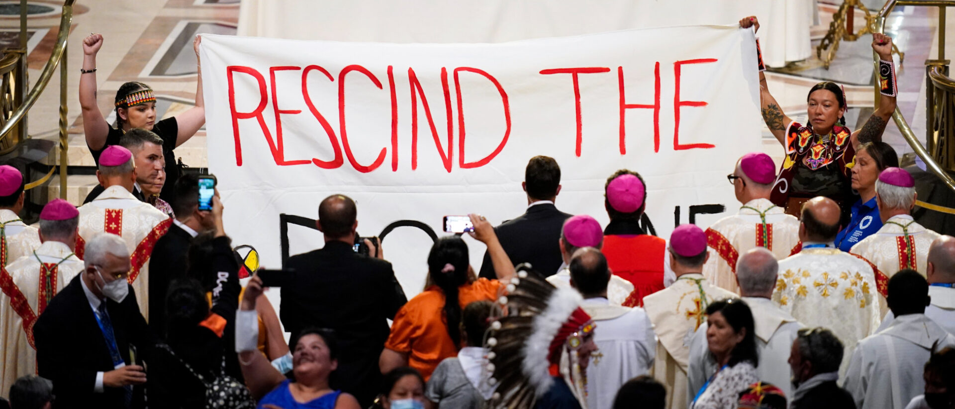 Indigene Frauen protestieren während der Papst-Messe in Kanada.
