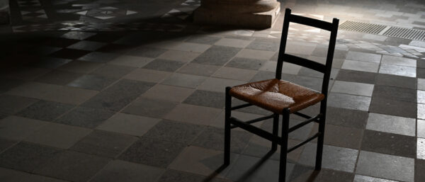 Stuhl in einer dunklen Kirche. | Harald Oppitz/KNA