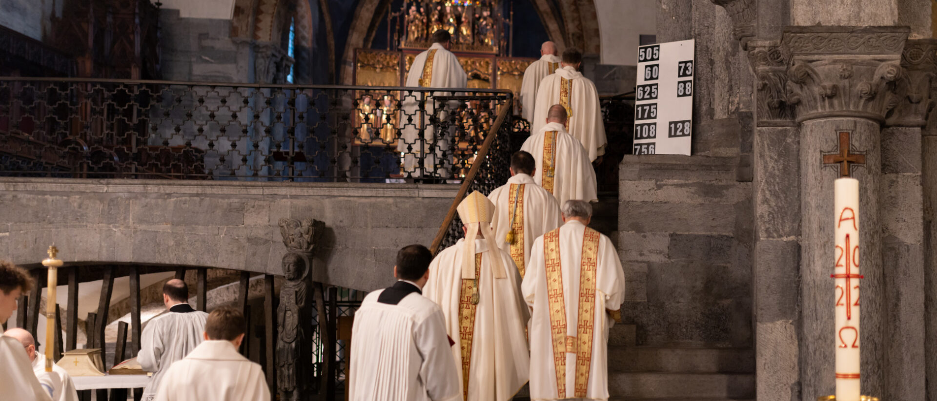 23 Priester ziehen durch die Kirche.