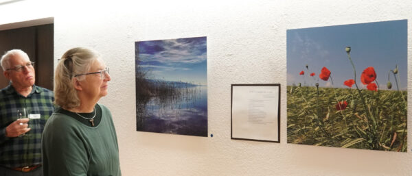 Gäste an der Vernissage sehen sich die Fotos von Eugen Trost an. | Vera Rüttimann