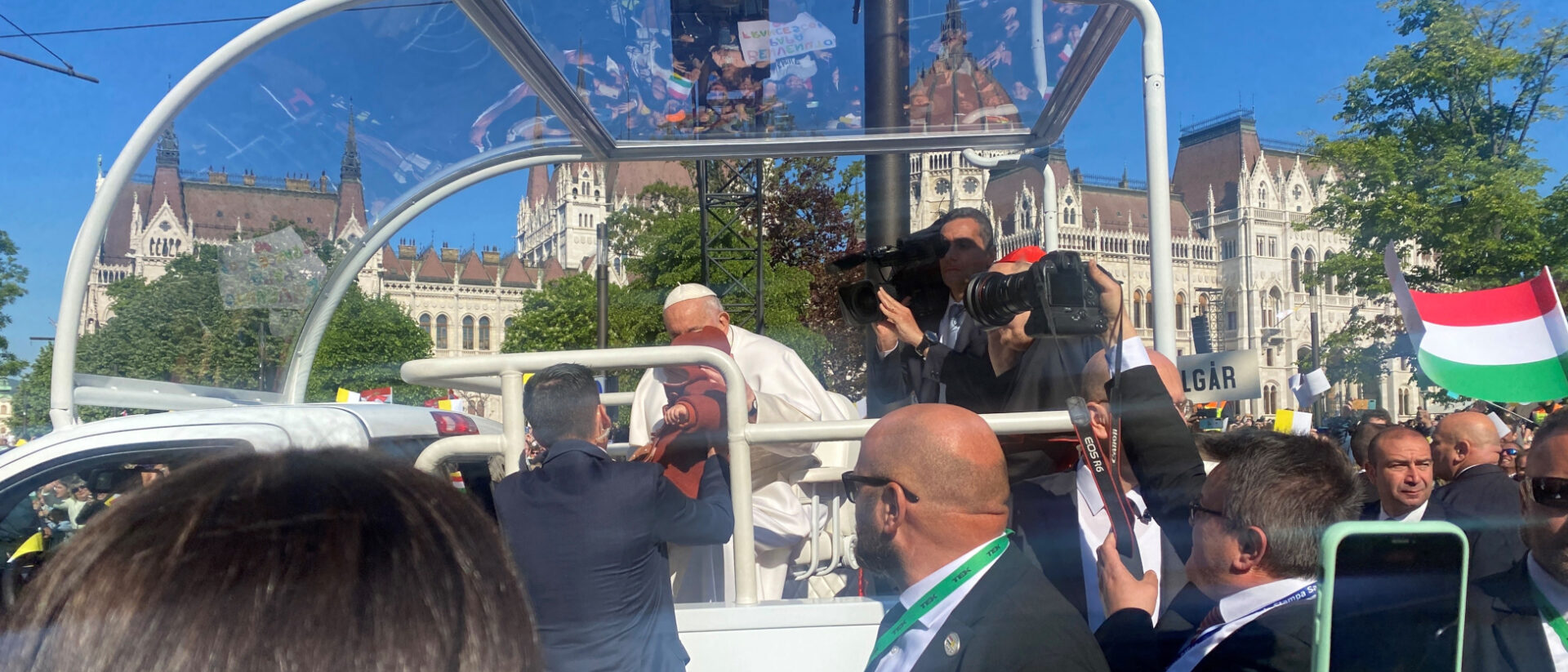Der Papst nimmt das kleine Mädchen entgegen und segnet es.