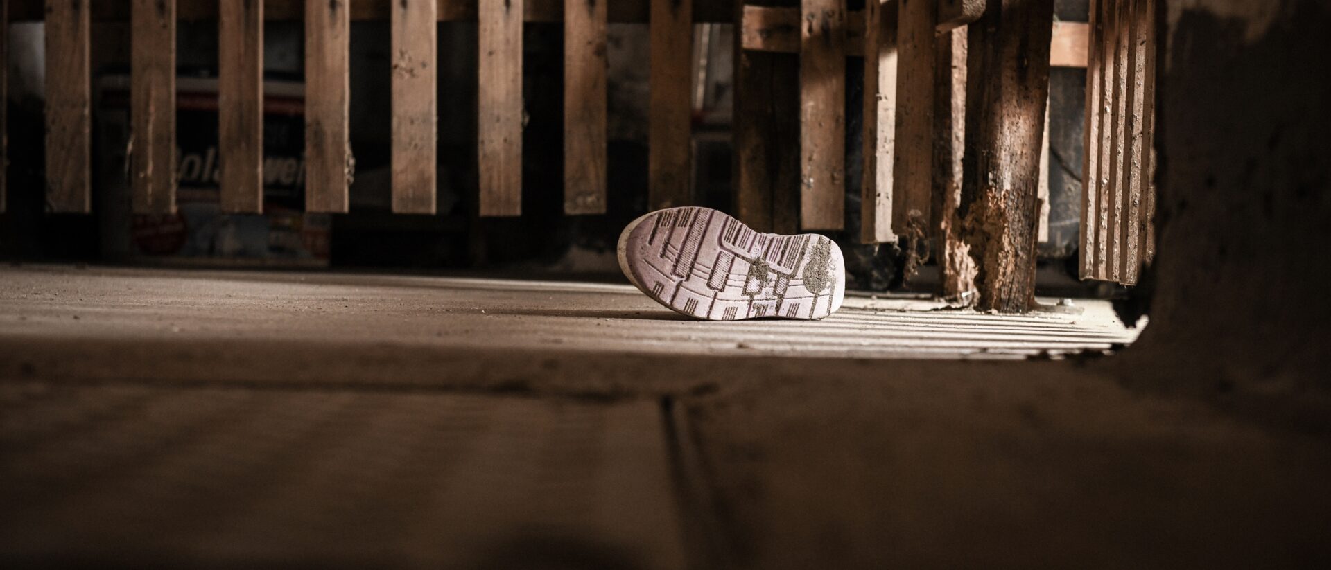 Ein Kinderschuh liegt auf dem Boden.
