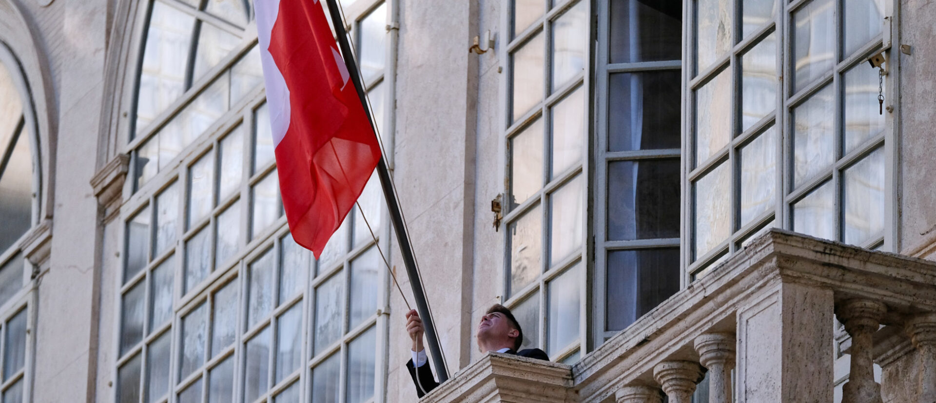 Ein Schweizergardist richtet die Schweizer Fahne.