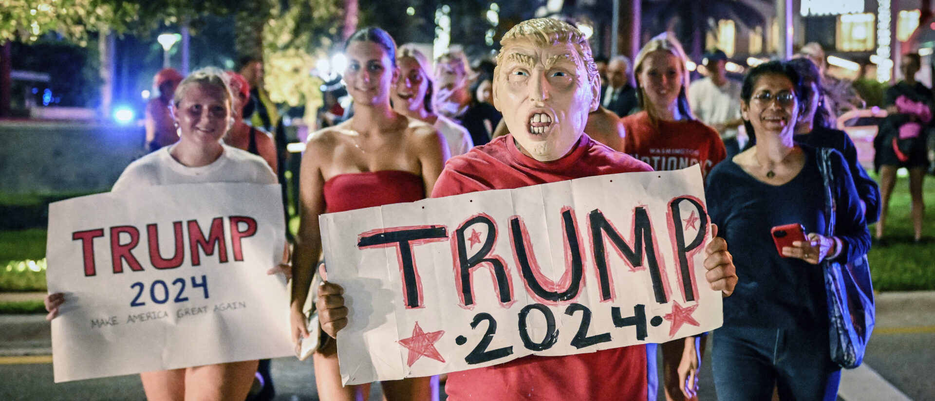 Trump-Anhänger mit Plakaten mit der Aufschrift "Trump 2024" feiern den Sieg von Donald Trump am 5. November 2024 in Palm Beach (USA).